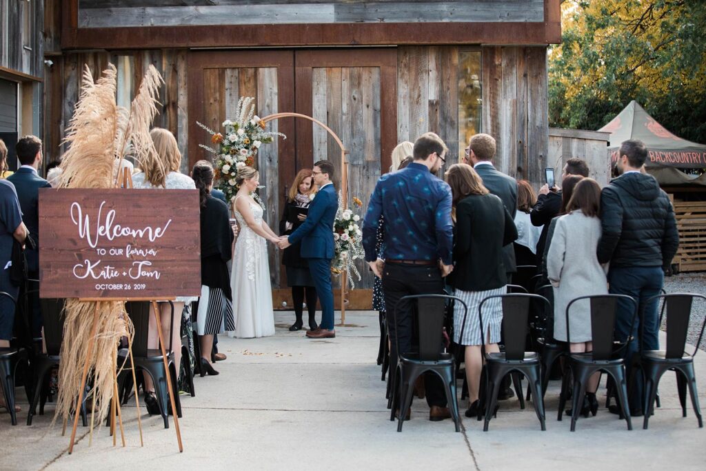 A ceremony outside at Oast House Brewers with people standing around