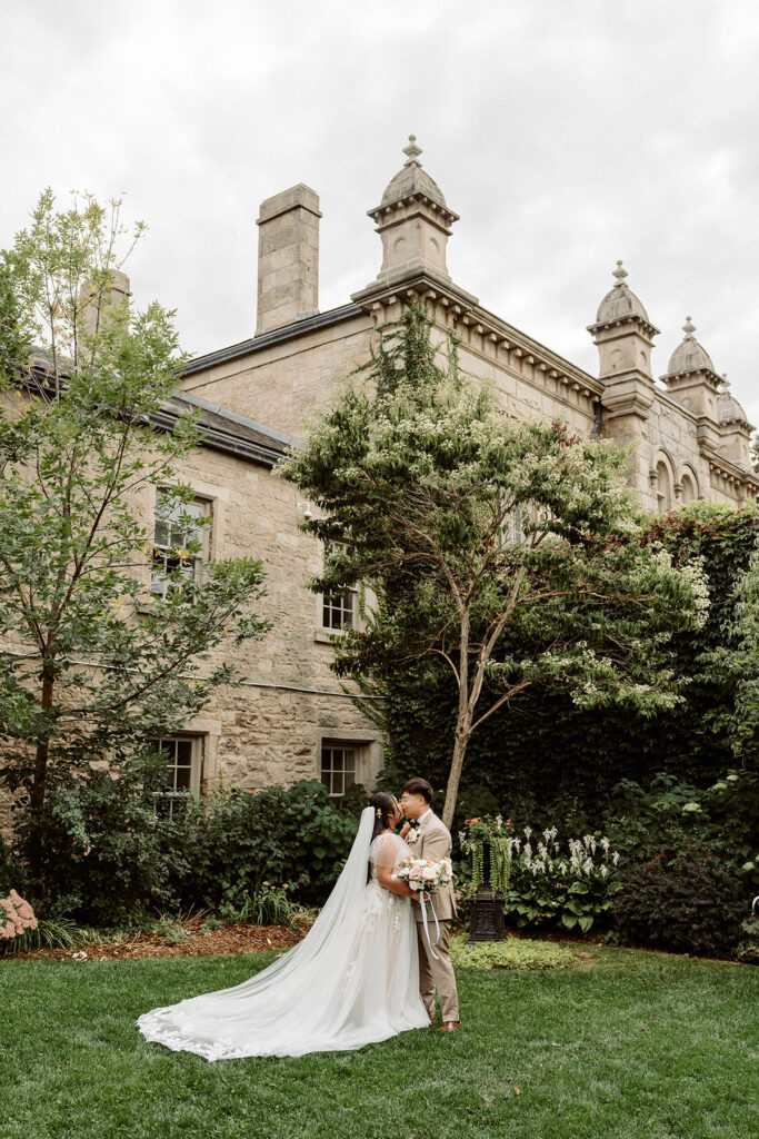 A couple kissing in front of a grand building