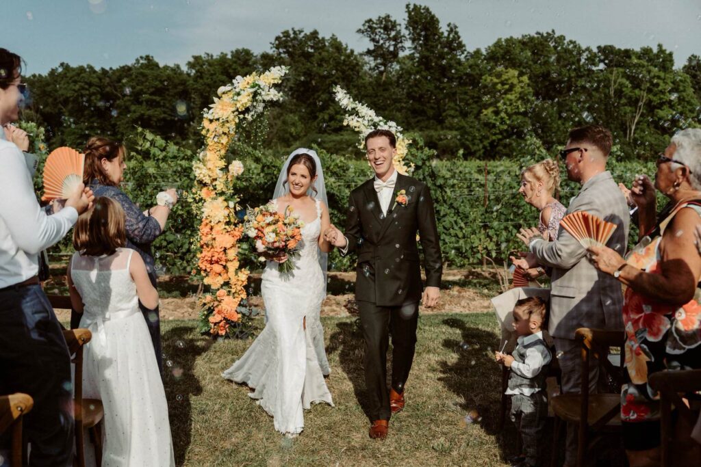 A couple walking down the aisle after being married outside