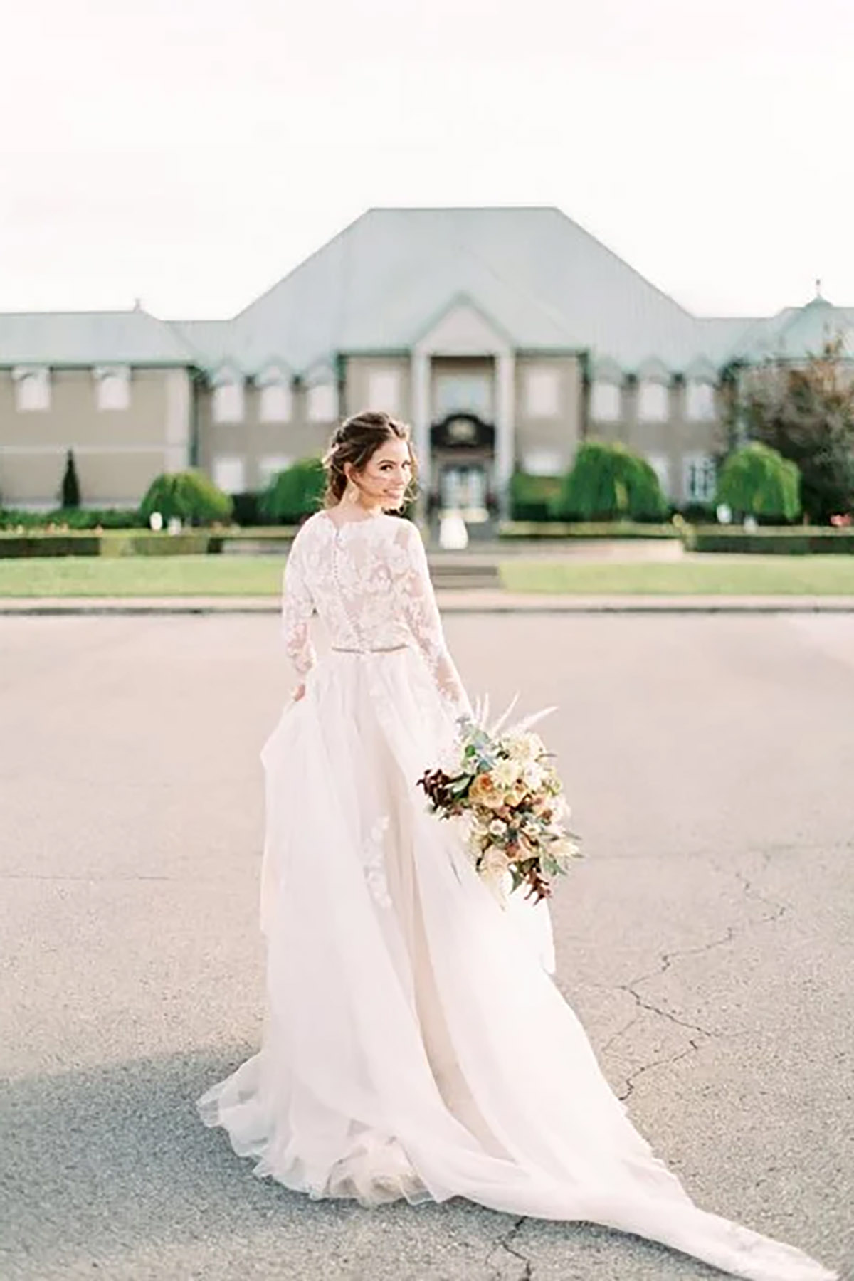 A bride walking away looking back with flowers in hand