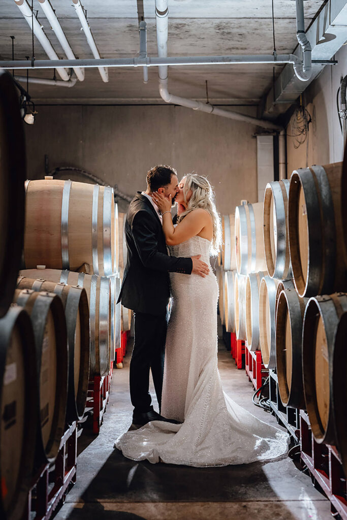 A couple, backlit, kissing in a wine cellar