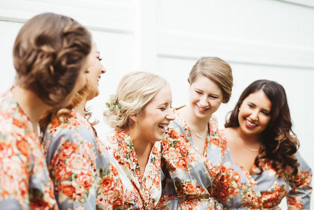 Bride and bridesmaids in morning robes laughing together