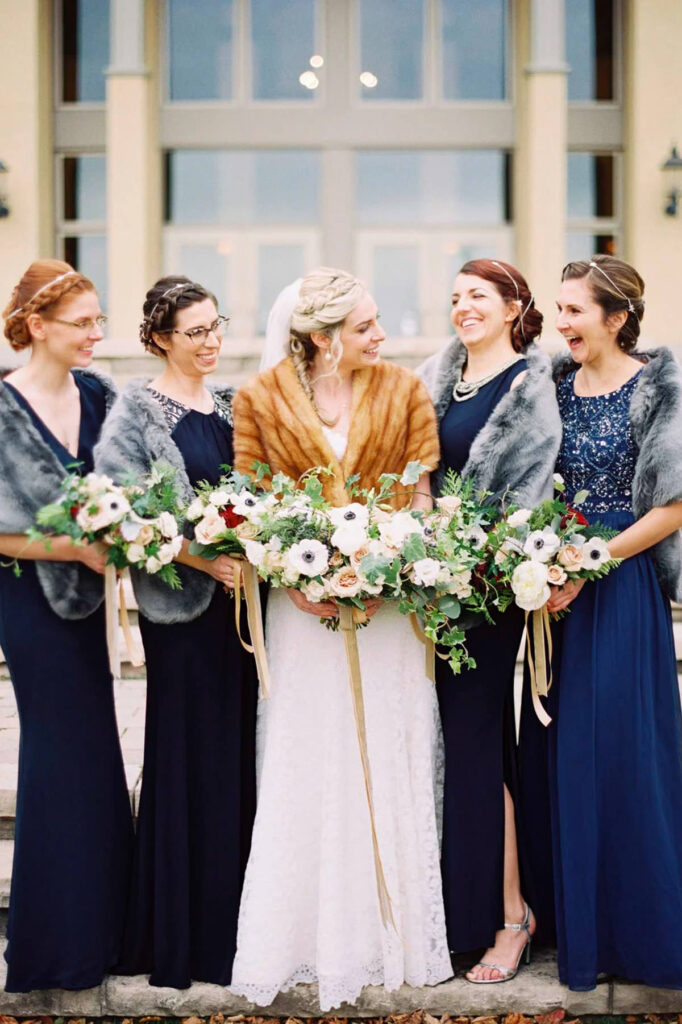 Bride and bridesmaids with shawls on looking and laughing