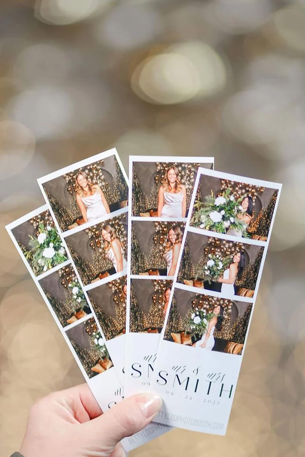 A hand holding 4 printed photo booth photo strips