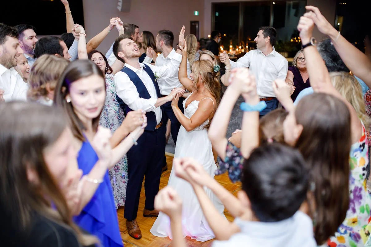 A couple in the middle of a crowd dancing at their wedding
