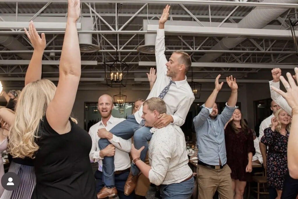 A group on a dance floor with a guy being lifted up