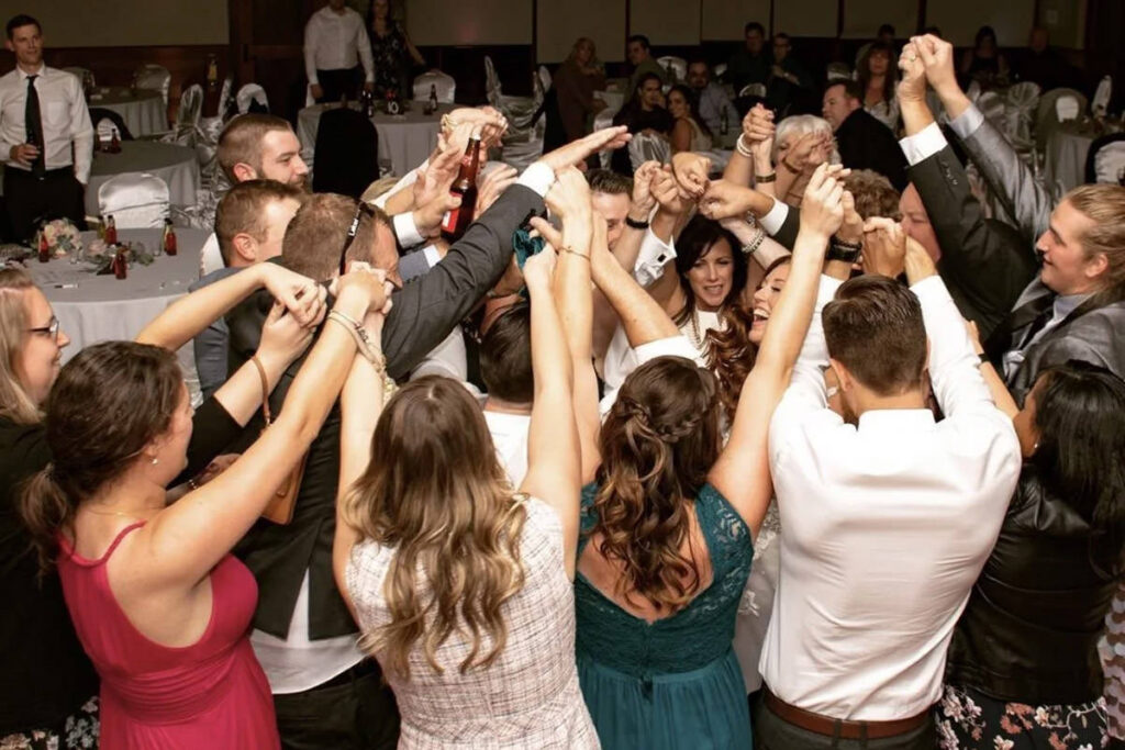 A couple in the middle of a crowd dancing at their wedding