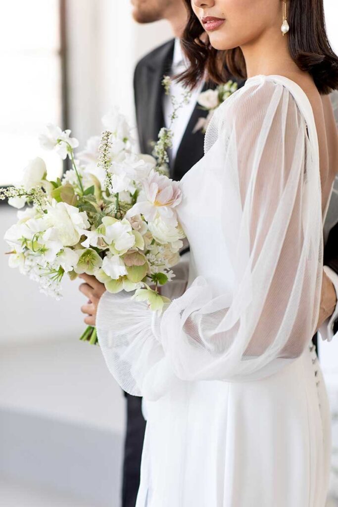 a side profile of a couple and the bride is holding her flowers up