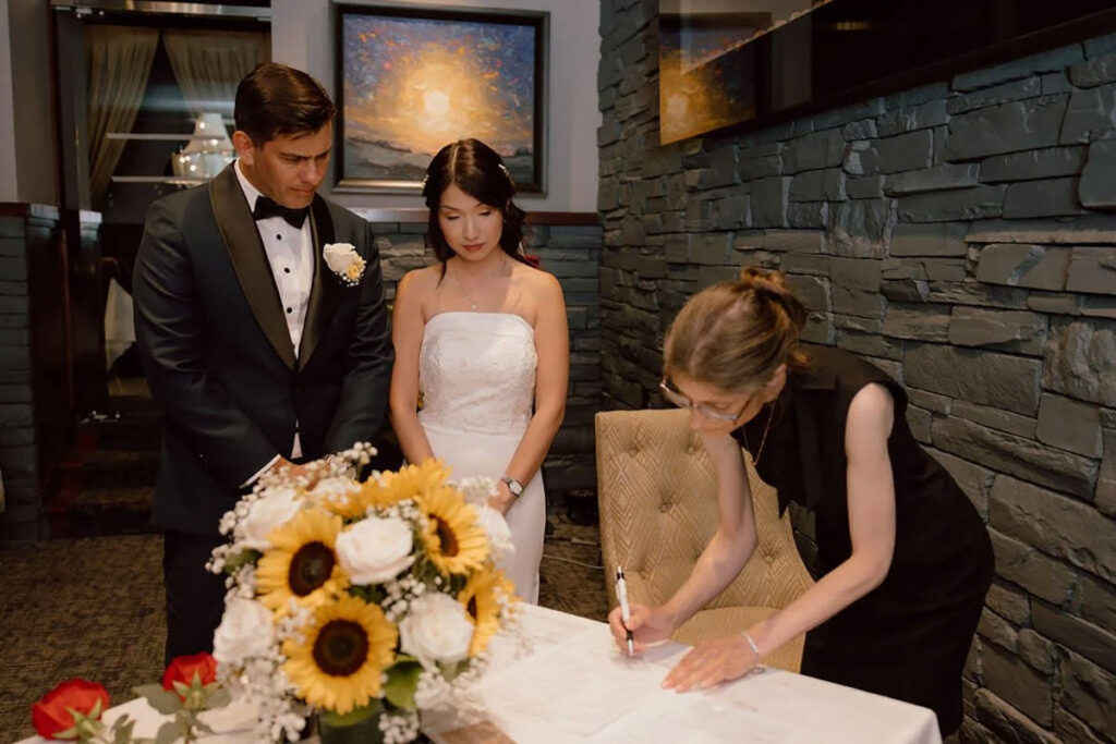 A couple signing their paperwork with their officiant