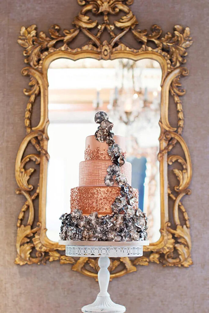 A stunning golden cake in front of a mirror