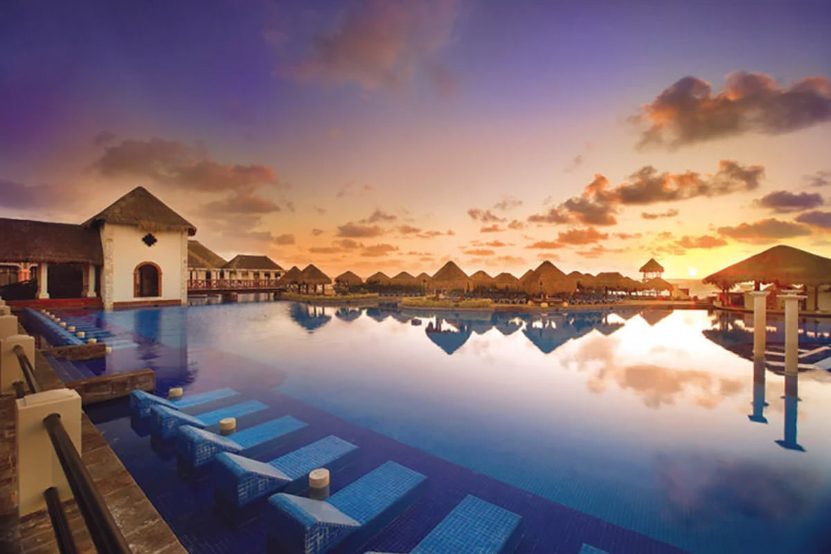 A beautiful sunset reflecting over the pool in a tropical location