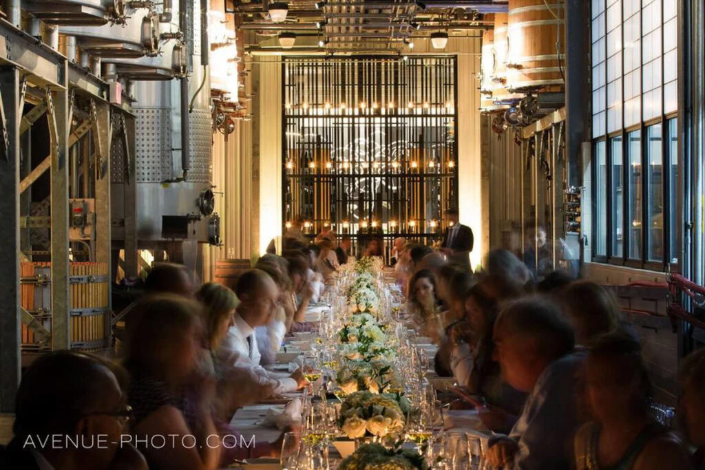 A dimly lit room with a long wedding table and candles