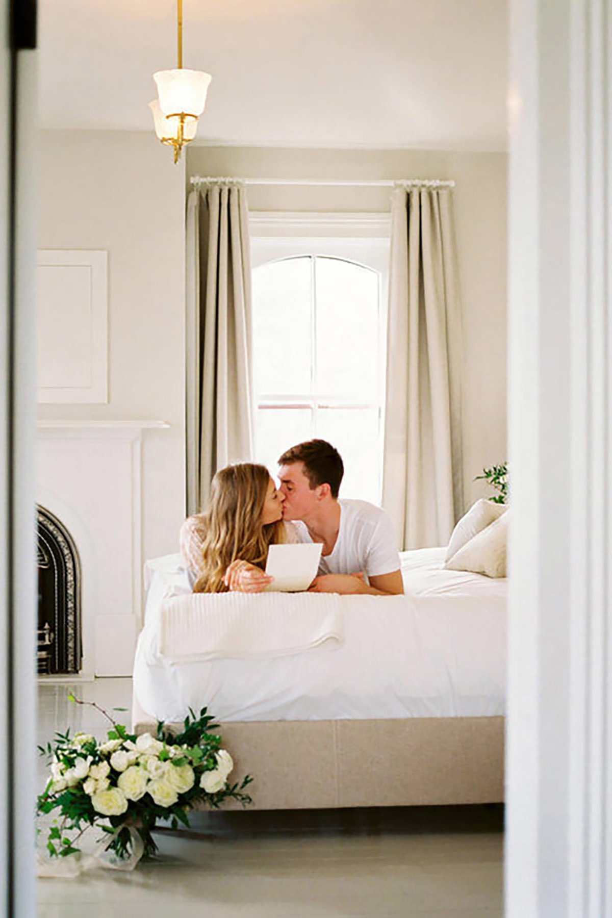 A couple cuddling up on a bed while ready a menu in a bed and breakfast