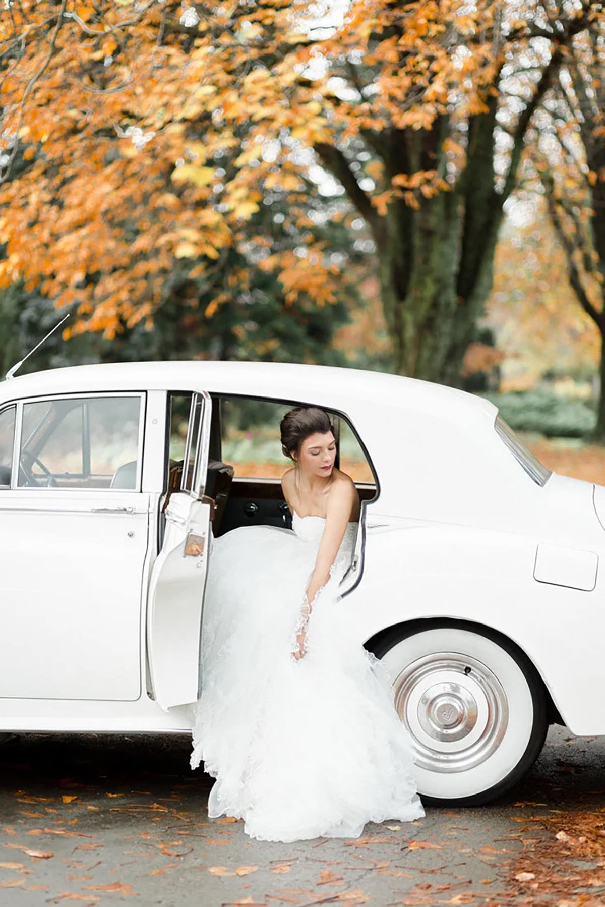 A bride coming out of a white classic car