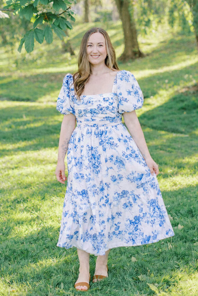 A headshot of a girl with long brown hair and a floral dress