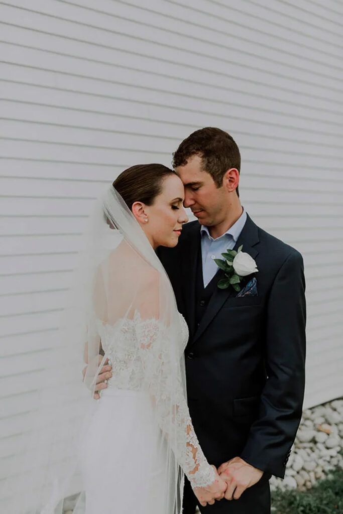 A couple with their foreheads together having a moment of silence on their wedding day