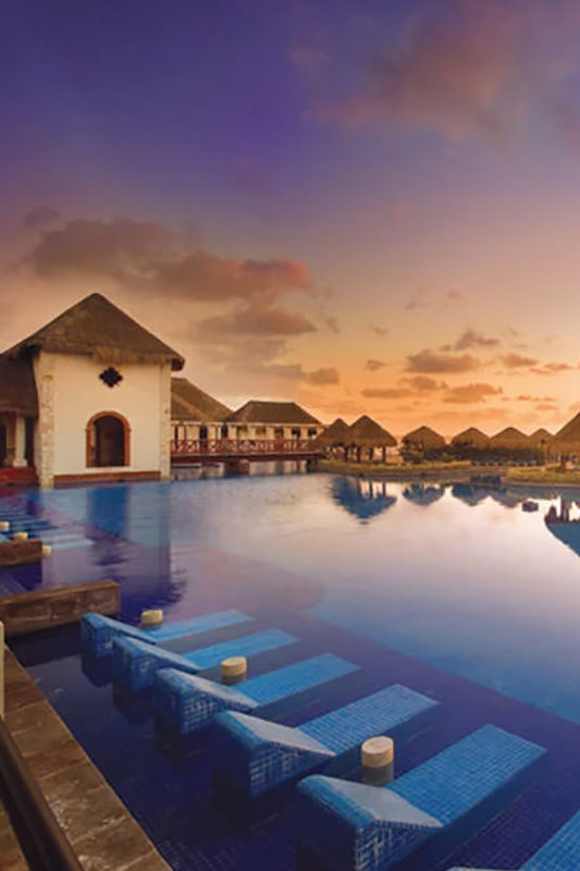 A beautiful sunset reflecting over the pool in a tropical location