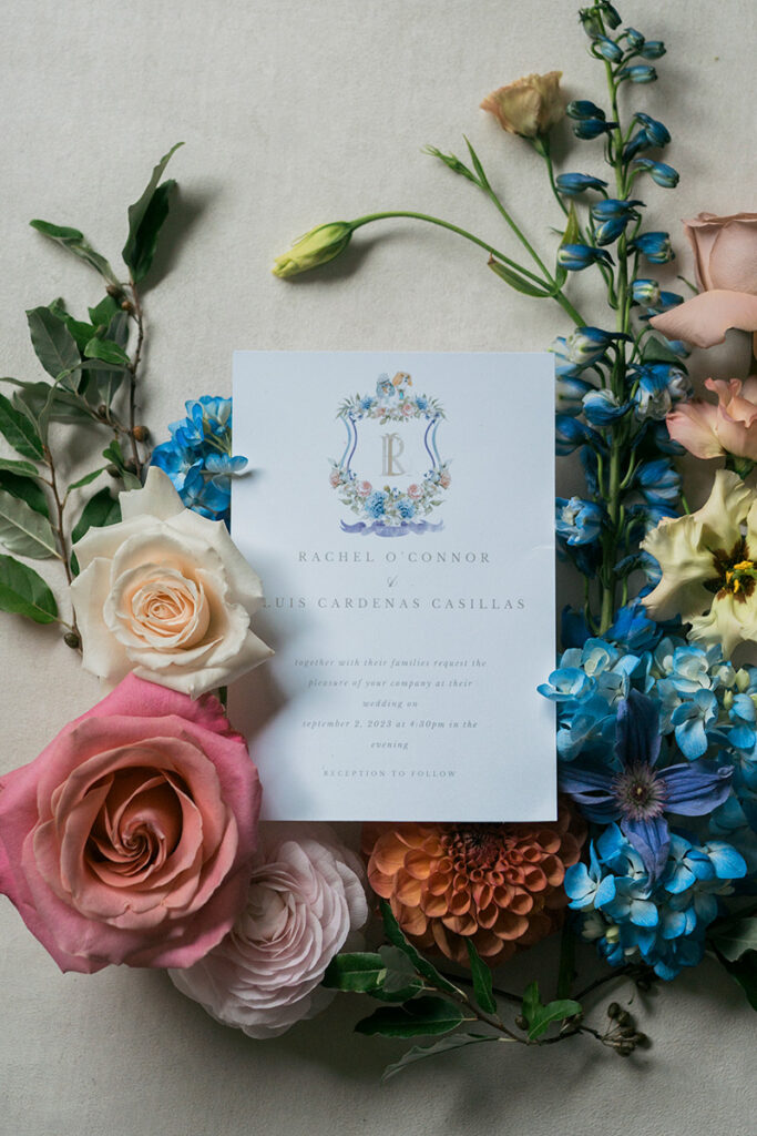 A close up of an invitation suite with flowers all around.