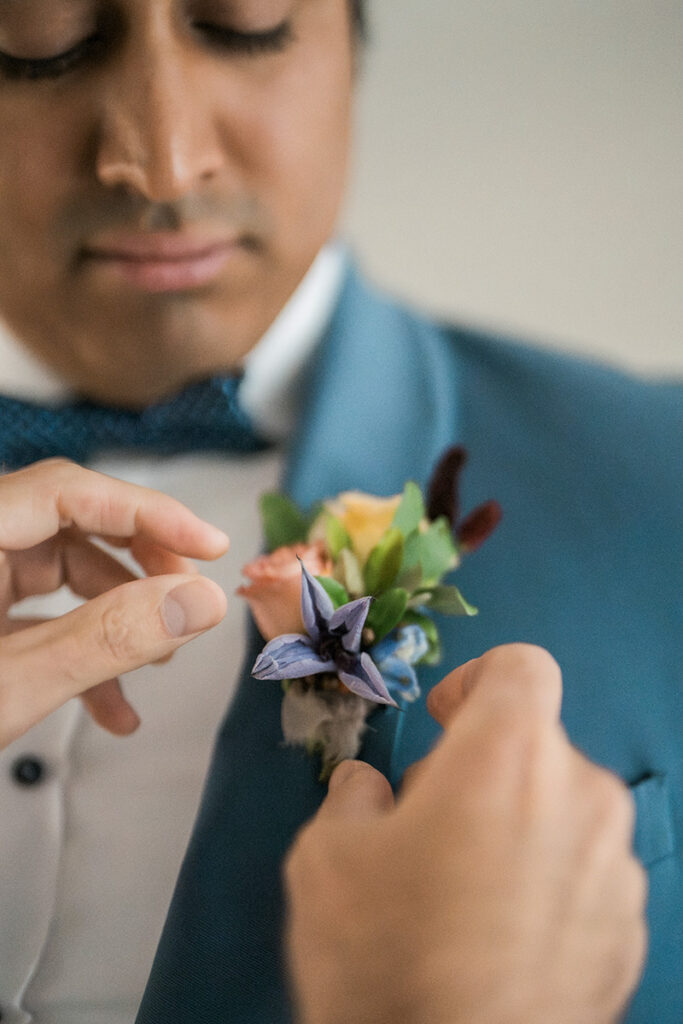 A boutonniere being put on a groom.