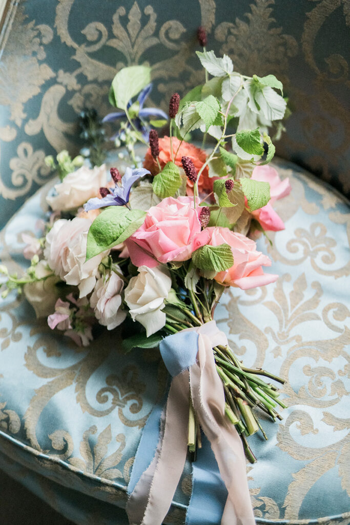A wedding bouquet on a blue chair.