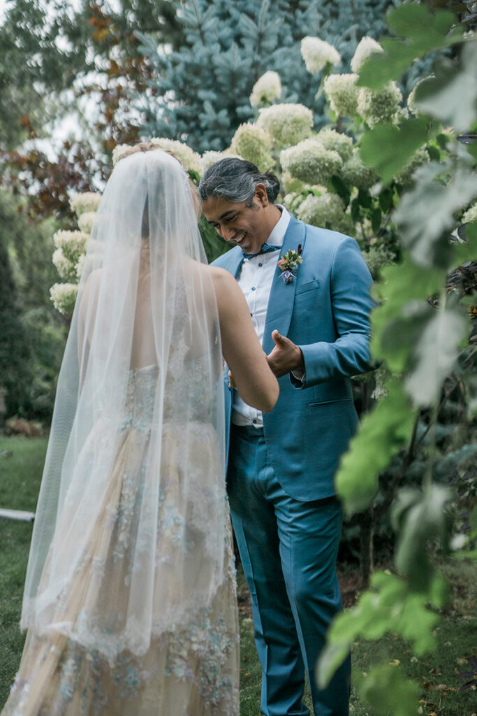 A couple among flowers and greenery.