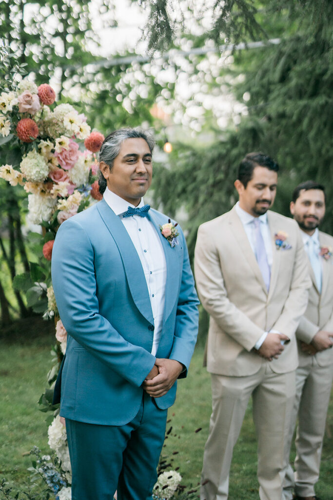 A groom and his groomsmen at an outdoor ceremony