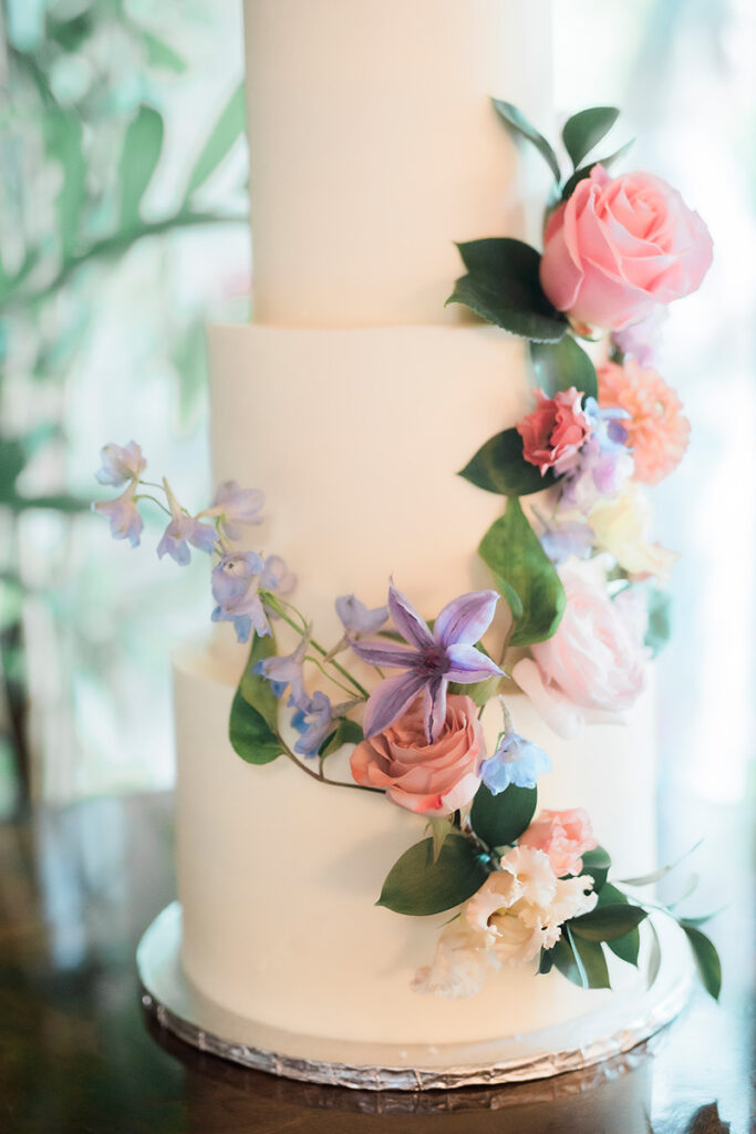 A 3 tier wedding cake with florals.