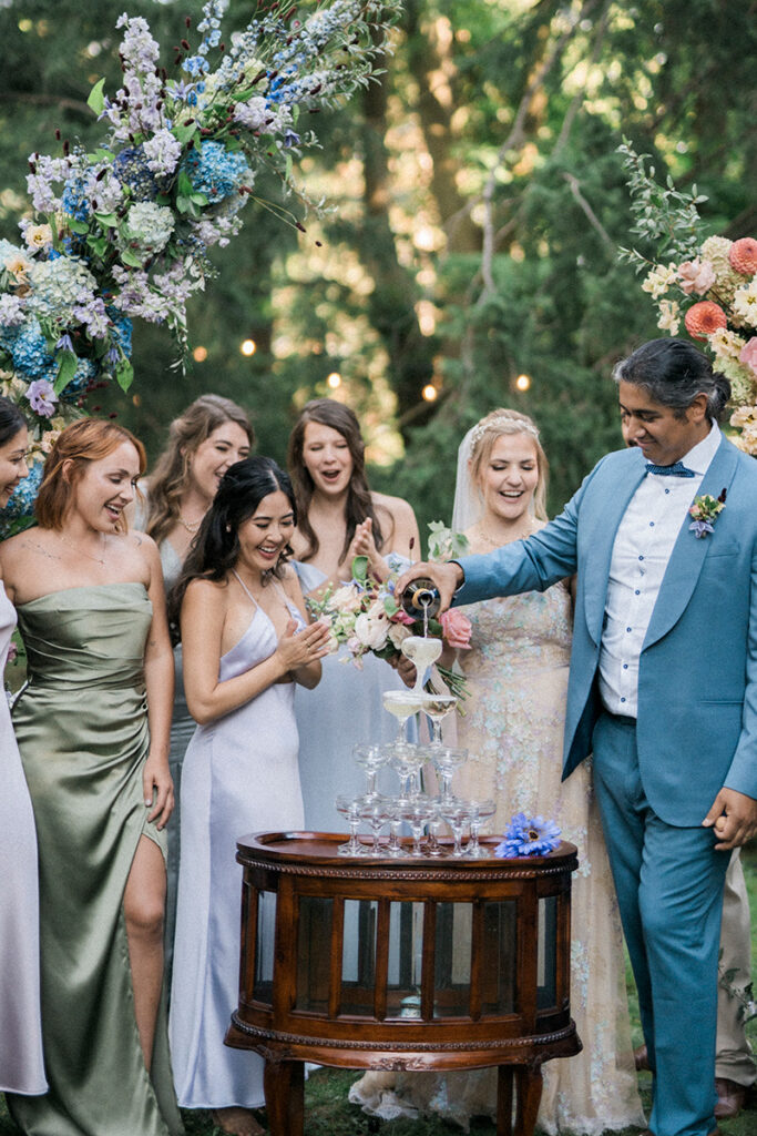 A couple pouring over a champagne tower.