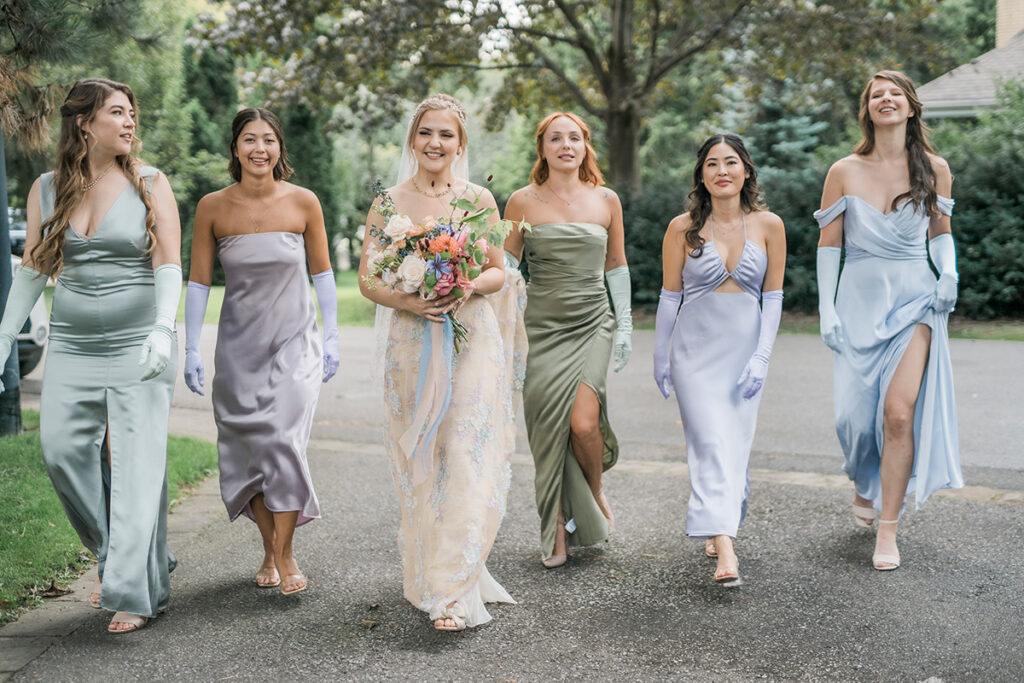 Ladies in a wedding party in Bridgerton inspired wedding dresses walking.