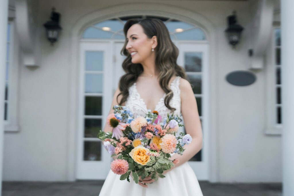 bride carrying a colourful bouquet of summer flowers