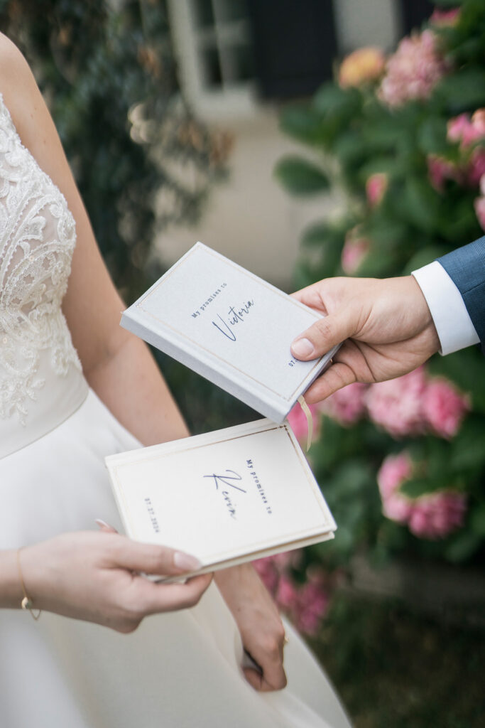 bride and groom holding their vow books