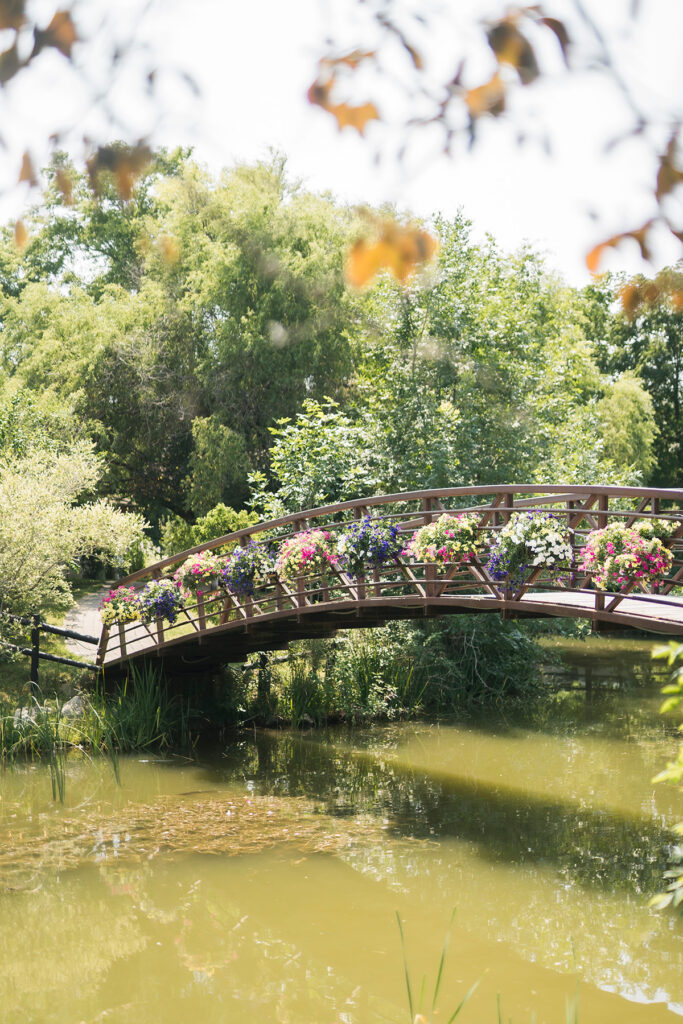 bridge over a pond decorated with hanging flower baskets