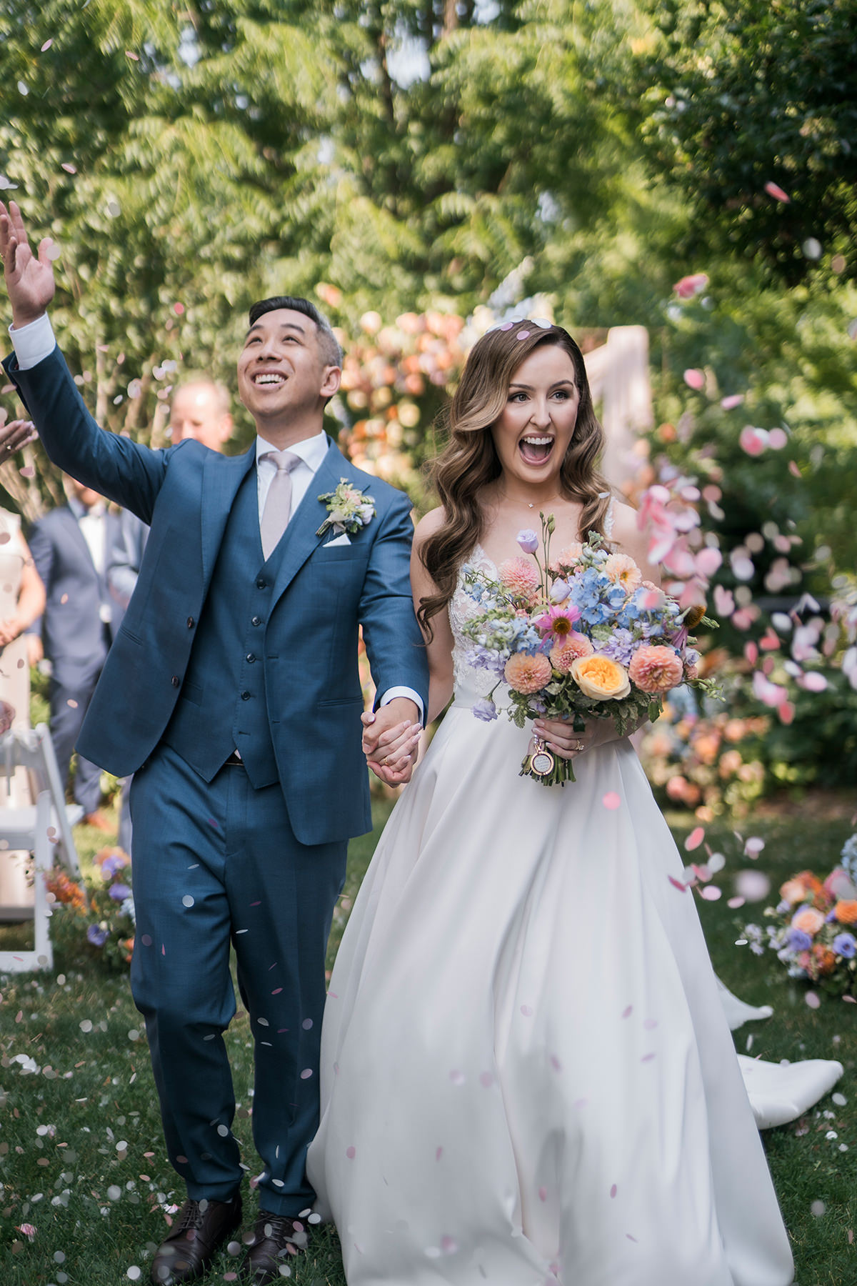 bride and groom showered with pink confetti