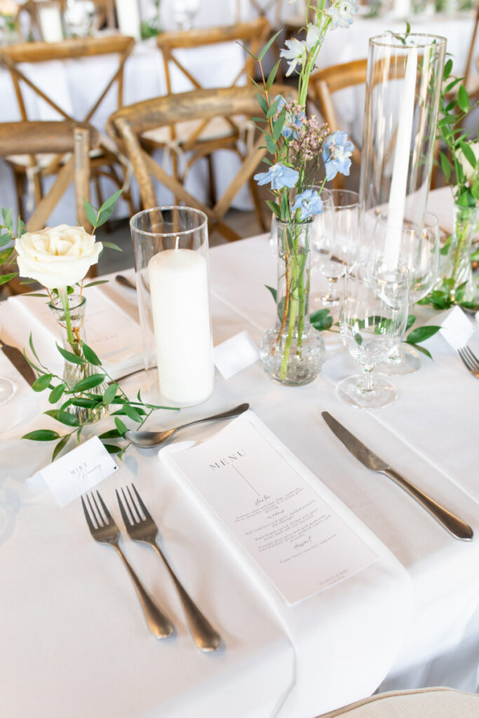 A tablescape showing a wedding menu and flowers.