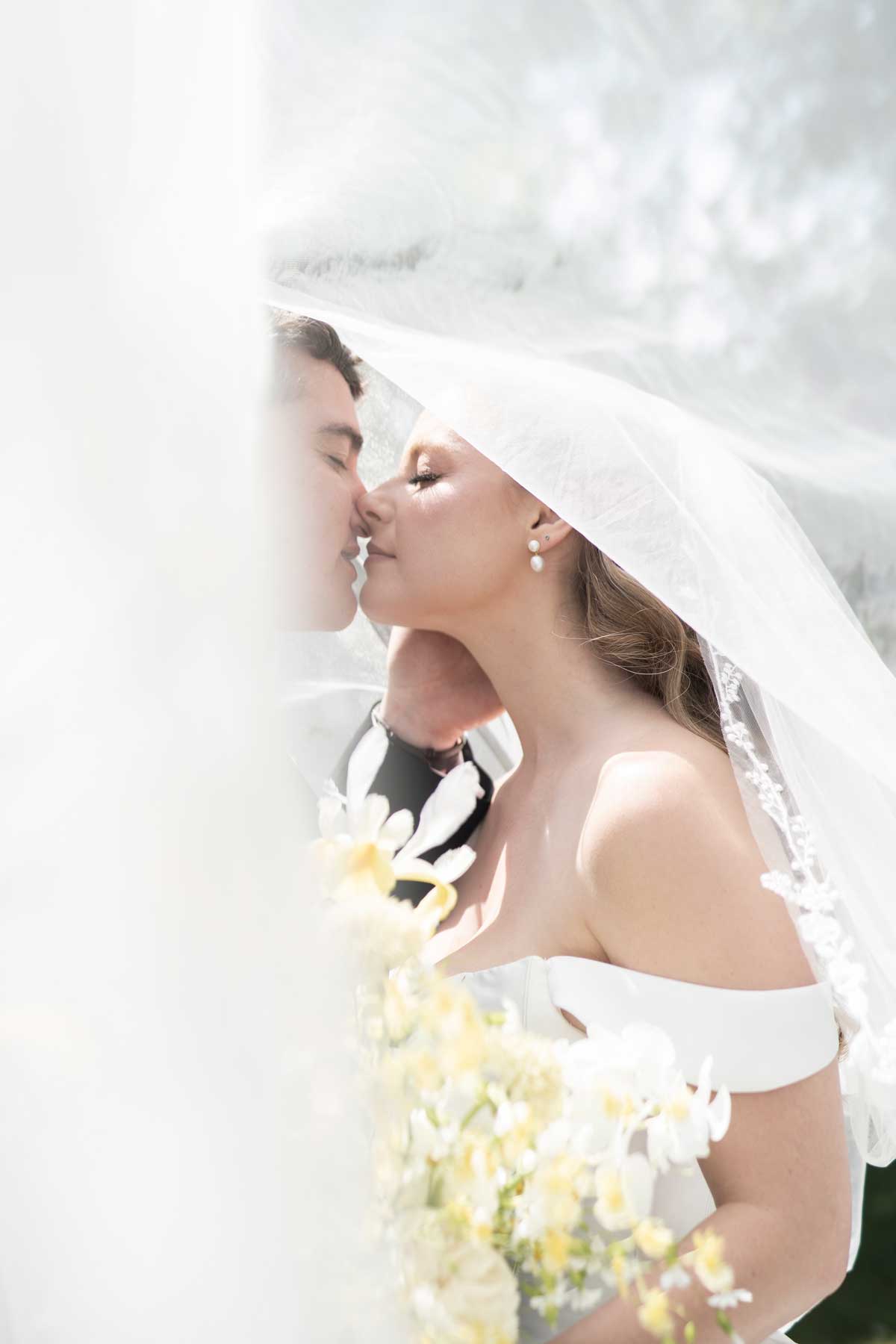 bride and groom under bride's veil