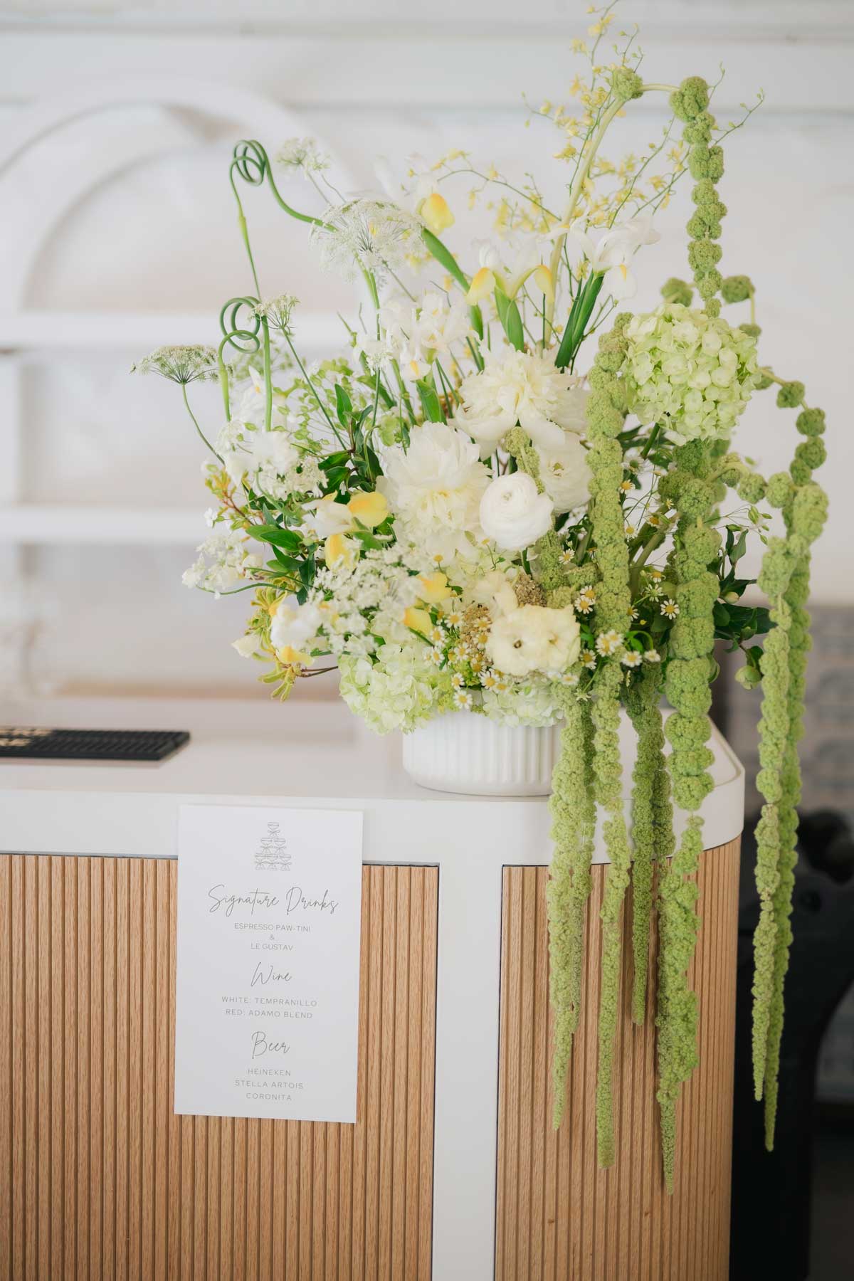 green and yellow floral arrangement on a cocktail bar