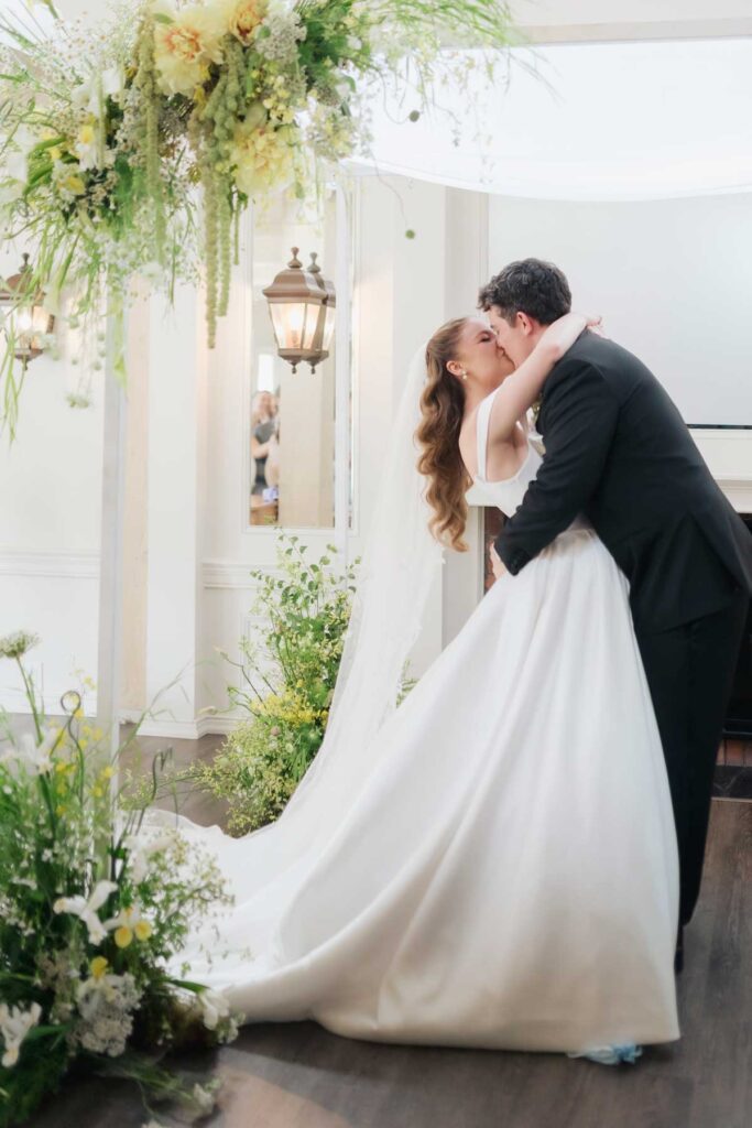 bride and groom sharing first kiss at ceremony
