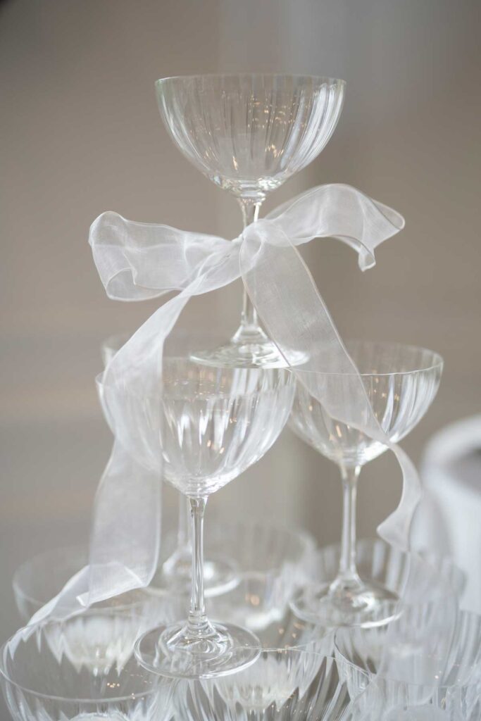 champagne tower with ribbon bows tied around each glass