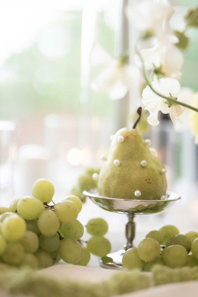 grapes and pear with small pearls as decor for wedding table