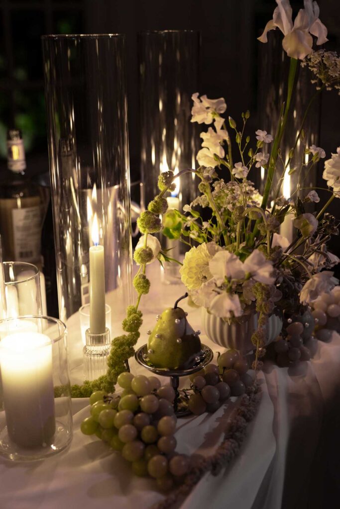 candlelit wedding reception table decor with green and white florals