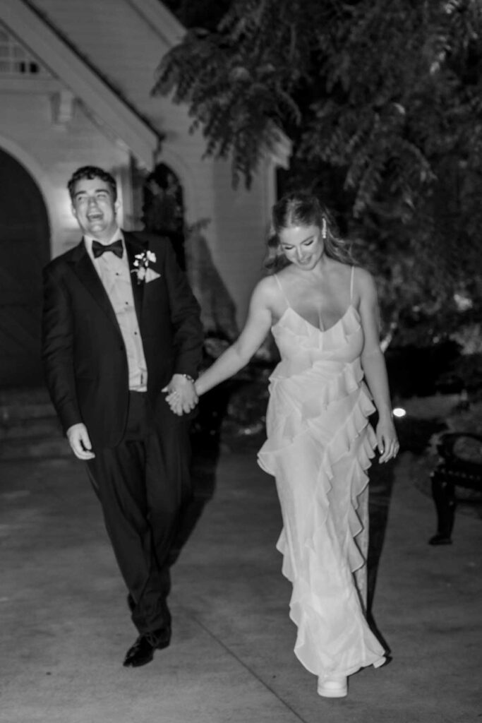 bride and groom walking outside wedding reception in evening