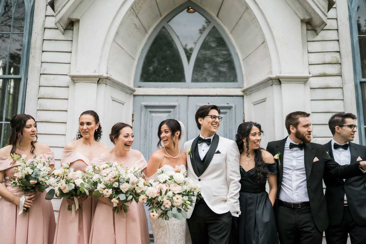 bridal party standing in front of chapel