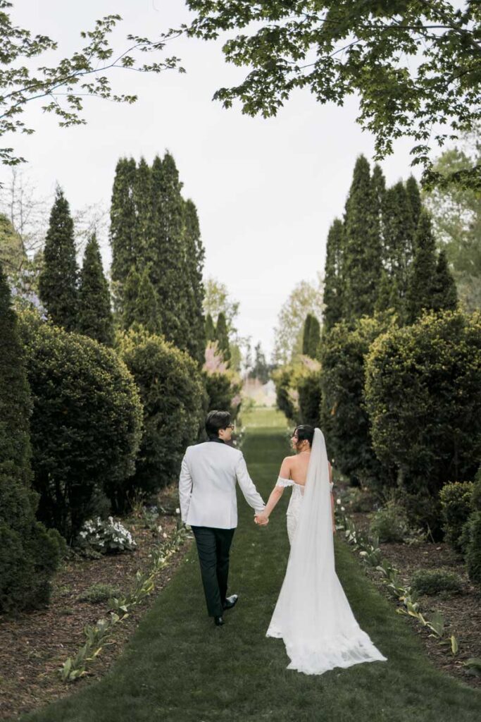 bride and groom walking outdoor tree lined path