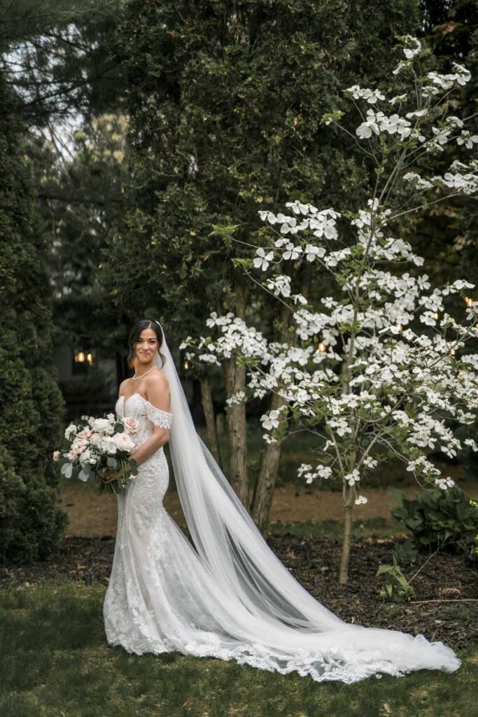 bride with a long cathedral length veil standing outside