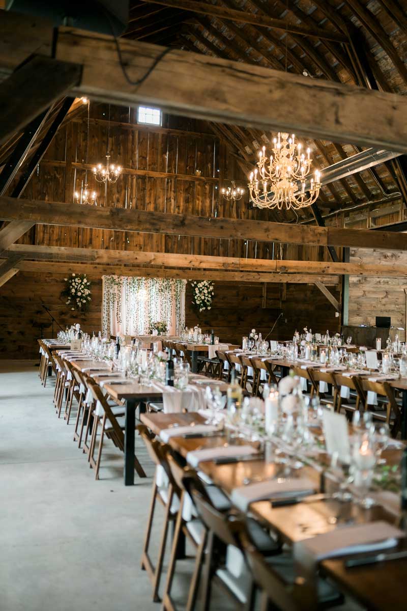 rustic barn wedding reception with long harvest tables
