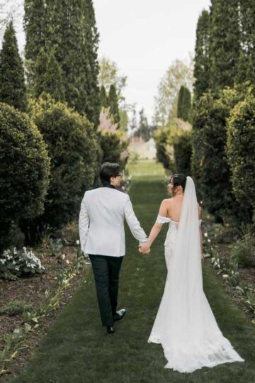 bride and groom walking outdoor tree lined path