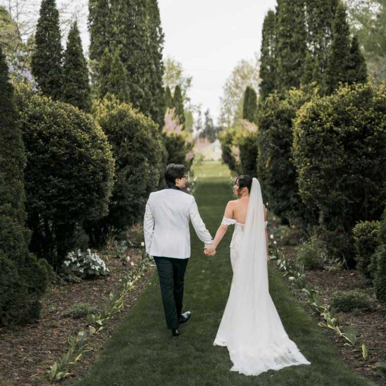 bride and groom walking outdoor tree lined path