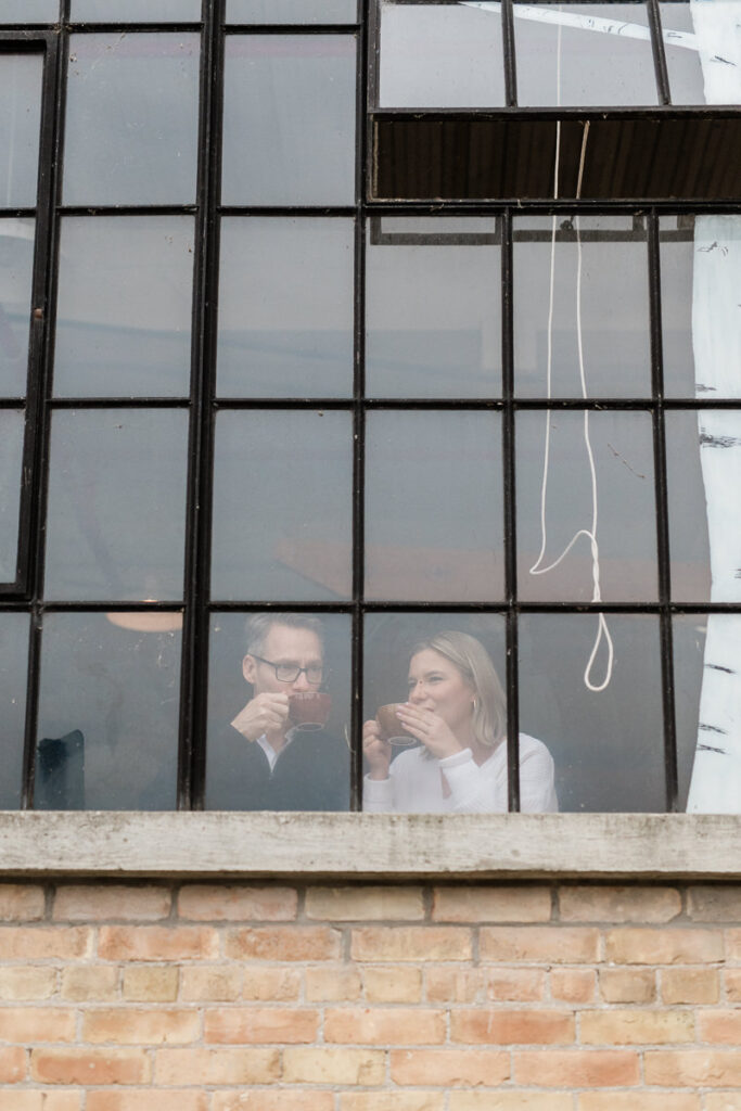 couple through a window in coffee shop drinking coffee