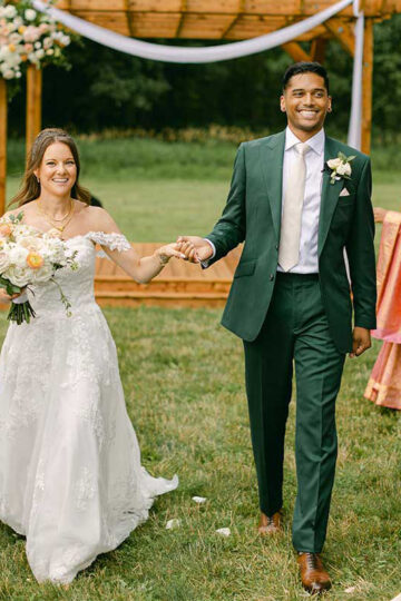 bride and groom holding hands walking up the aisle