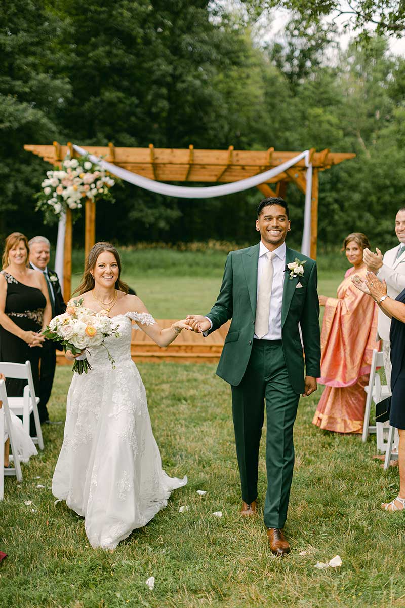 bride and groom holding hands walking up the aisle